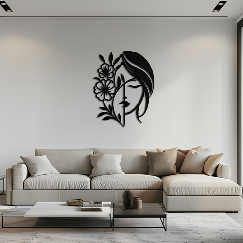 Black metal laser-cut wall art of a woman's face in profile with flowing hair and large floral blooms, mounted above a cream sectional sofa in a bright modern living room