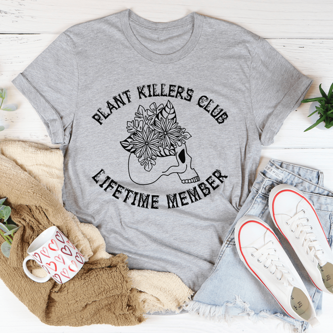 Plant Killers Club Lifetime Member graphic tee in athletic heather, flat lay styled with jeans, sneakers, and a cozy blanket