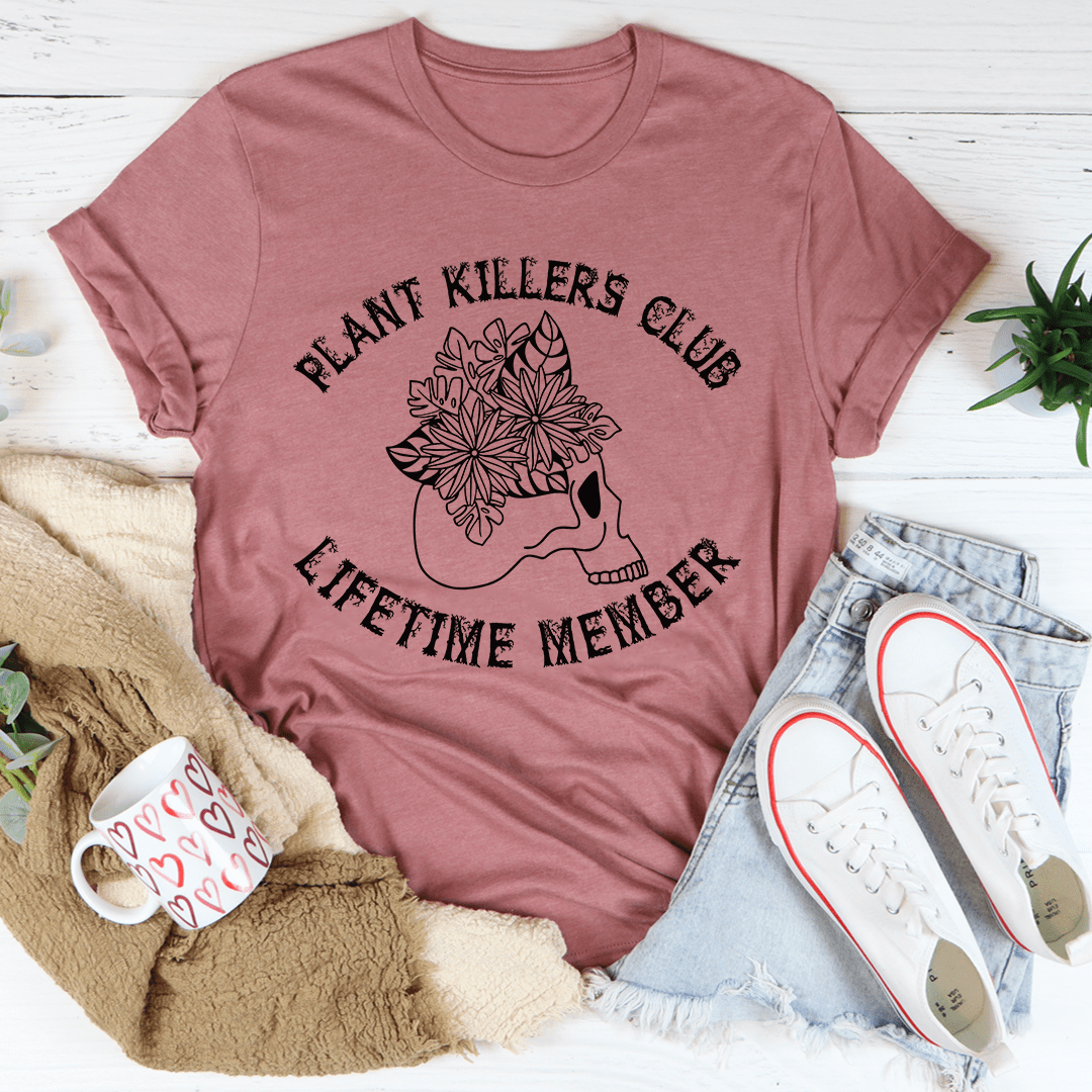 Plant Killers Club Lifetime Member graphic tee in mauve, flat lay styled with jeans, sneakers, and a cozy blanket